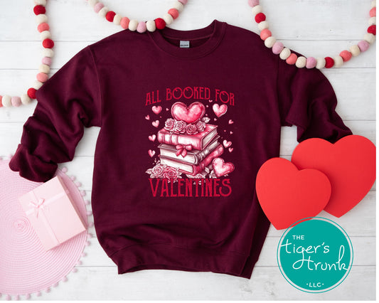 Shirt with stacked books, hearts, and roses, featuring the phrase "All Booked for Valentine’s." Perfect for book lovers.