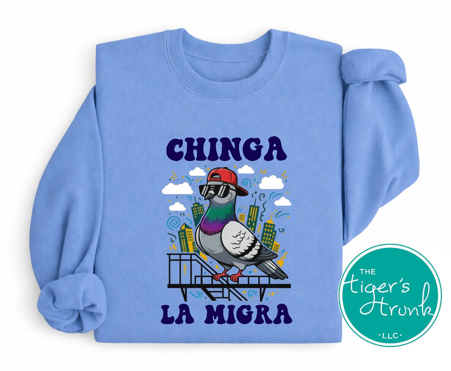 Blue sweatshirt with a graphic of a pigeon and text 'CHINGA LA MIGRA' on a white background.