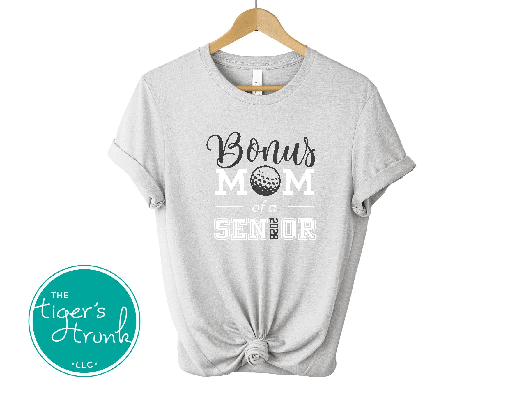 Gray t-shirt with 'Bonus Mom of Senior' text on a hanger, branded with 'The Tiger's Trunk'.