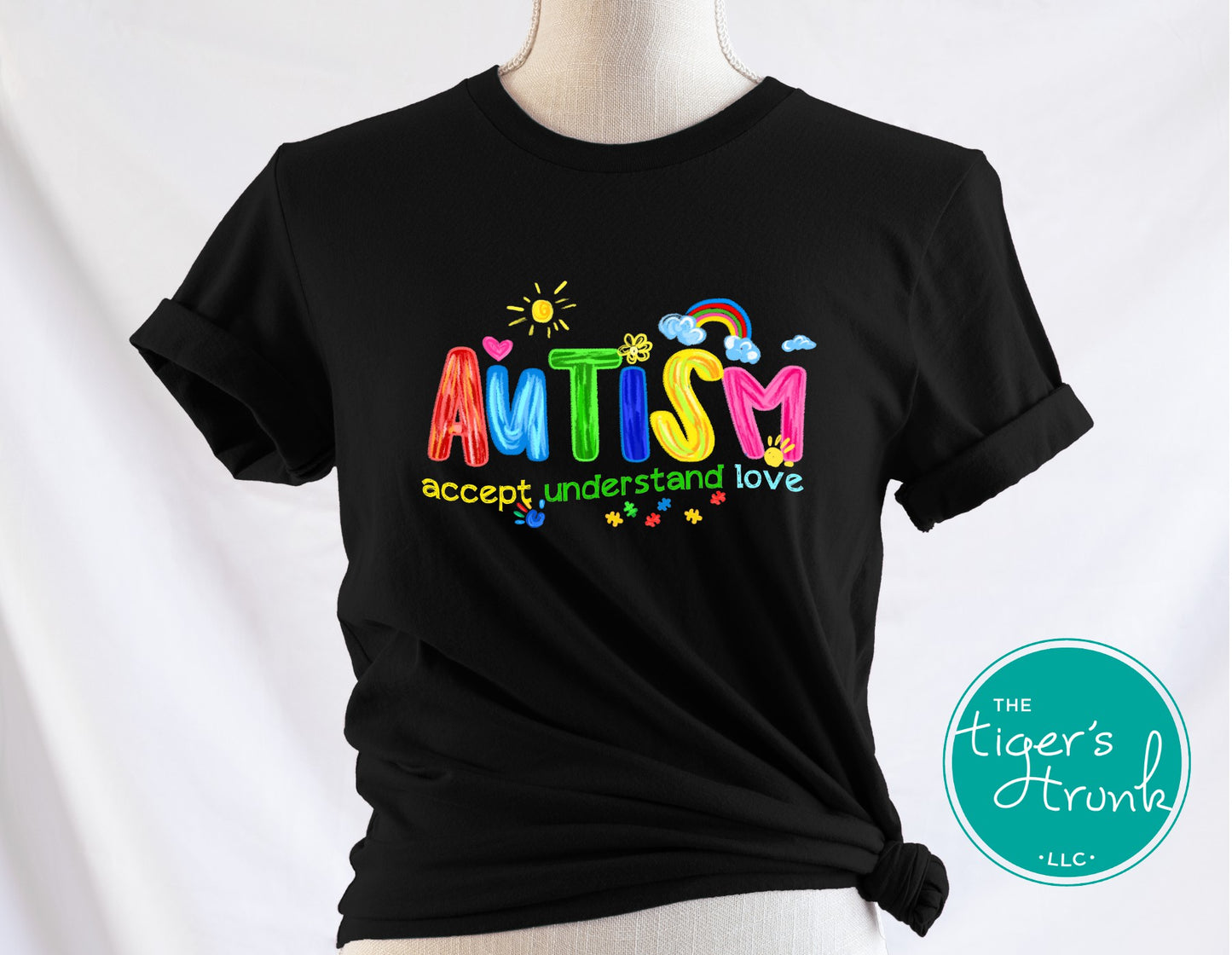 Black t-shirt with colorful 'AUTISM accept understand love' text on a mannequin against a white background.