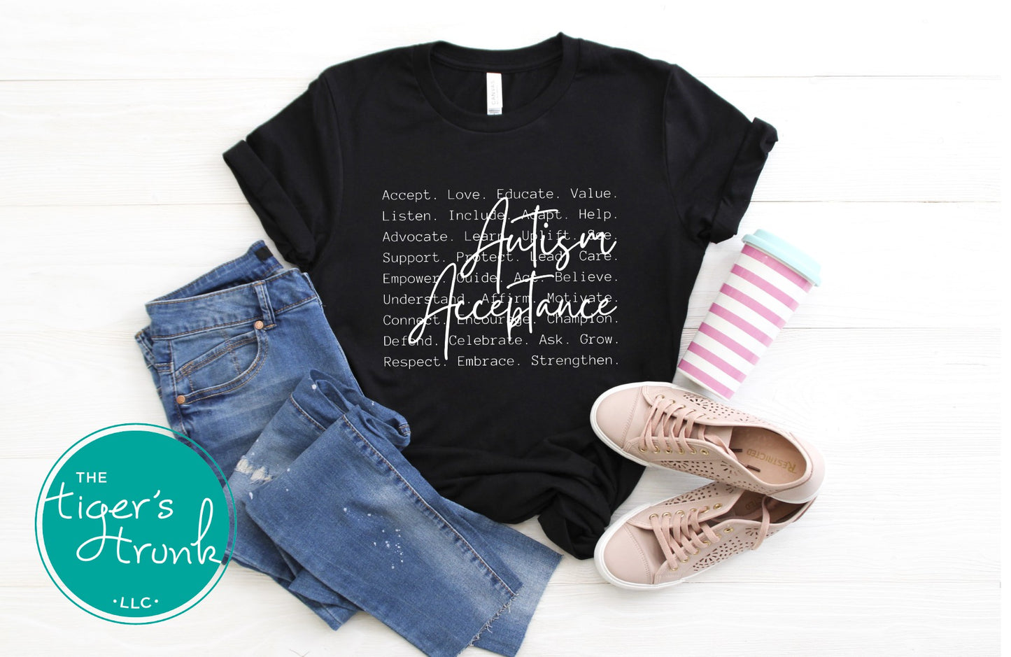 Black t-shirt with 'Autism Acceptance' text, blue jeans, and pink sneakers on a white background.