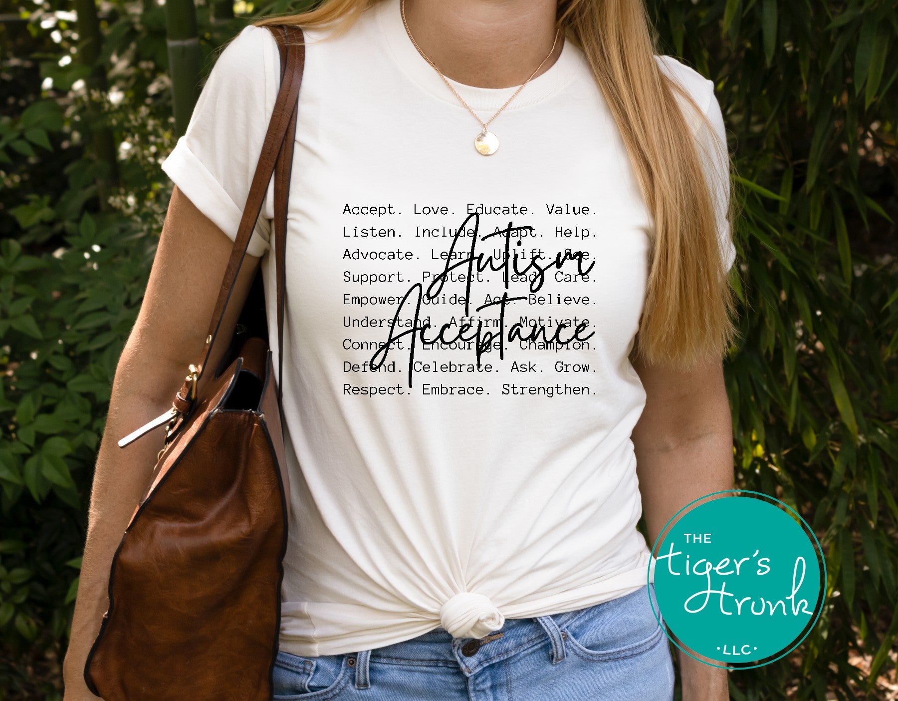 Person wearing a white t-shirt with 'Autism Acceptance' text, standing outdoors.