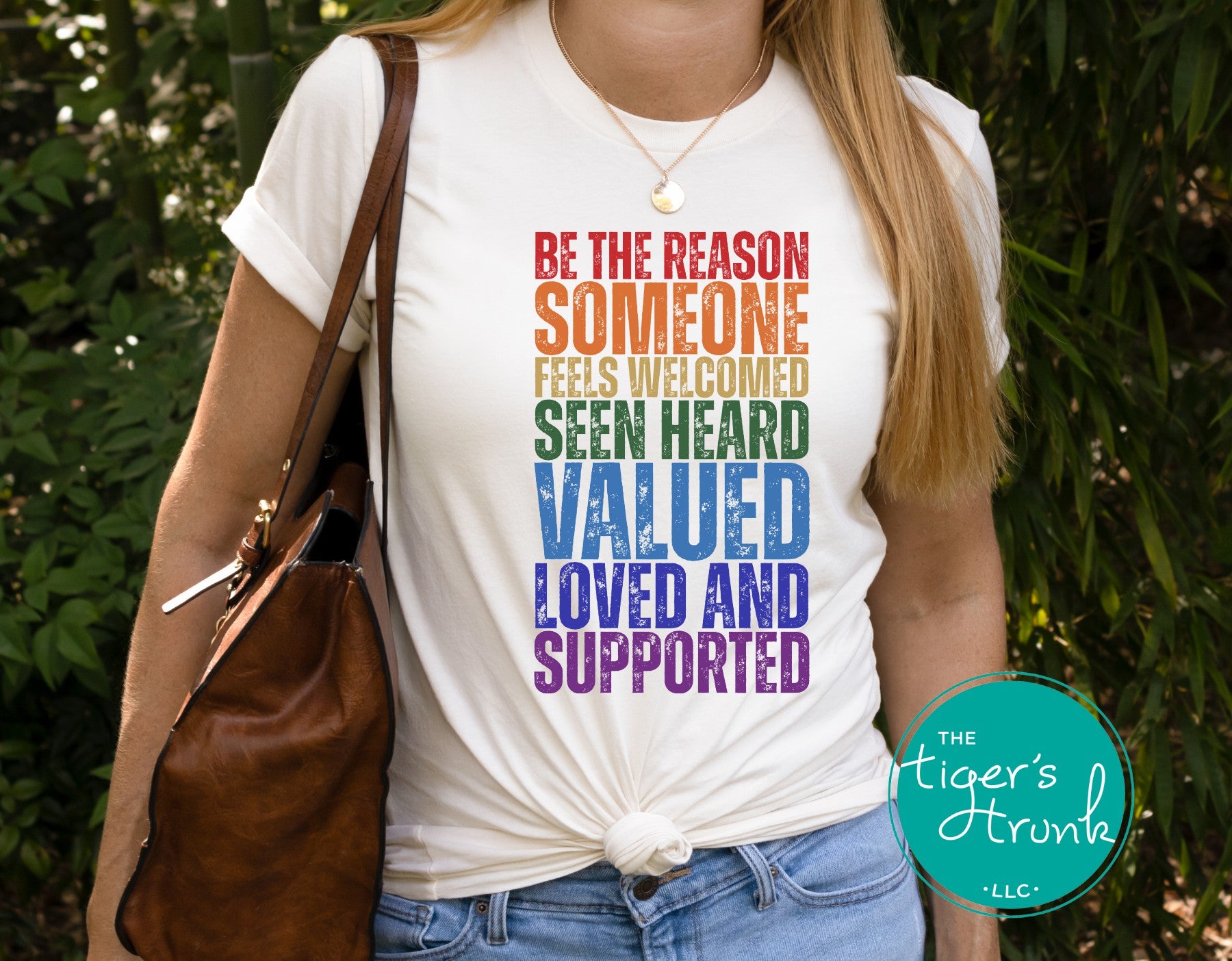Person wearing a white t-shirt with motivational quote, standing outdoors.