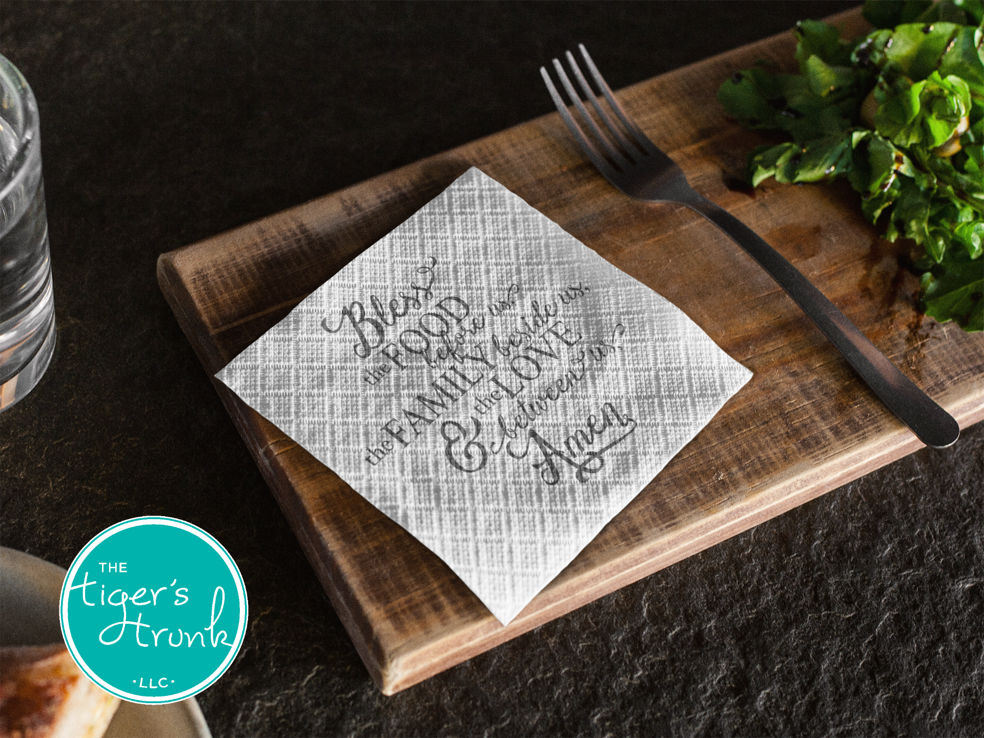 Napkin with text on a wooden cutting board with a fork and water glass, featuring 'The Tiger's Strumpf' logo.
