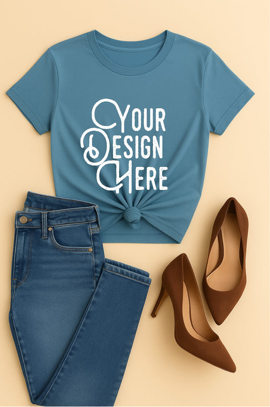 Blue t-shirt with 'Your Design Here' text, paired with blue jeans and brown shoes on a beige background