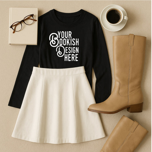 Black long-sleeve shirt with 'Your Bookish Design Here' text, white skirt, tan boots, glasses, and coffee cup on a beige surface.