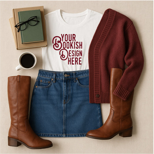 White t-shirt with 'Your Bookish Design Here' text, blue denim skirt, brown knee-high boots, red cardigan, green book, and coffee cup on a beige surface.