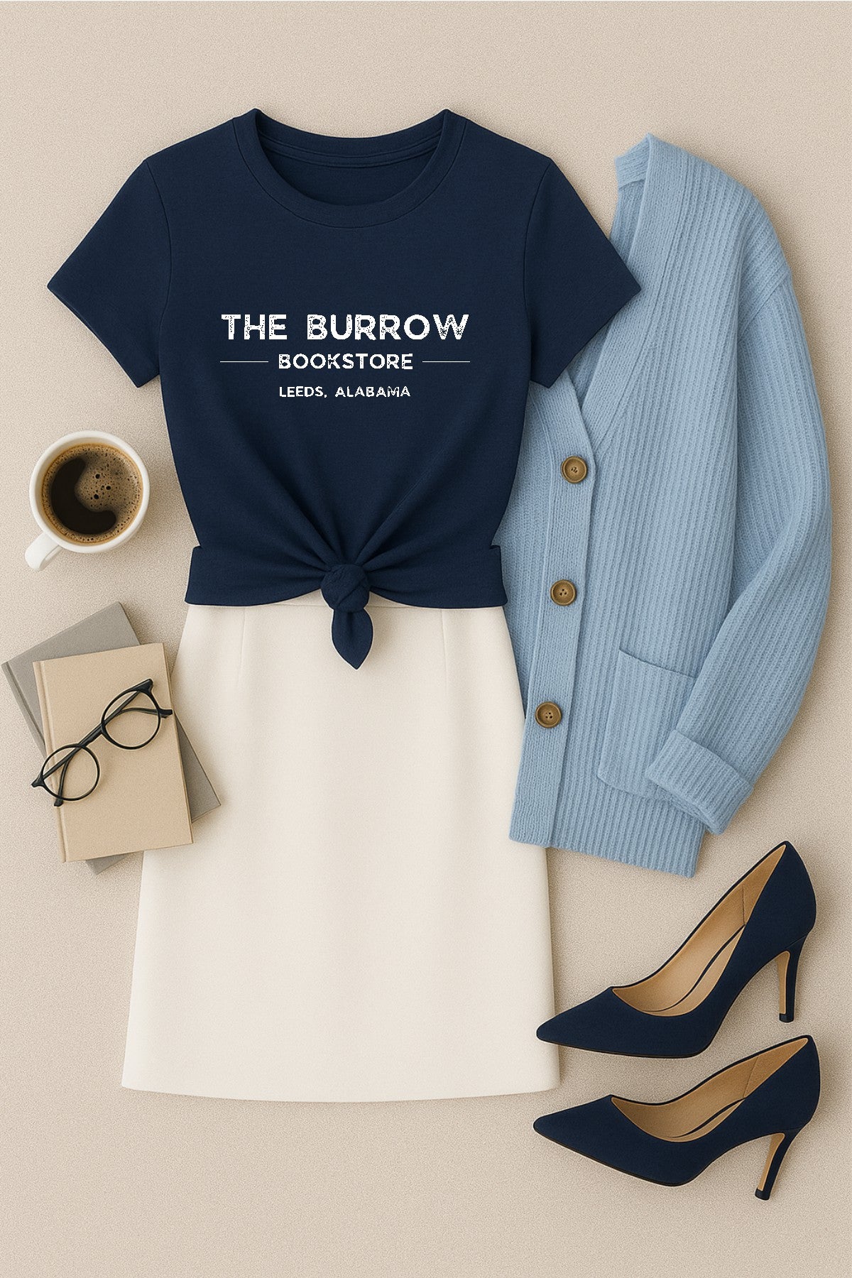 Navy t-shirt with 'The Burrow Bookstore' text, white skirt, blue cardigan, high heels, coffee, glasses, and books on a beige background.