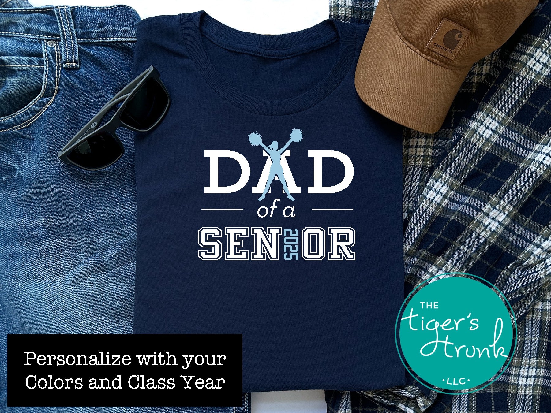 Navy Cheer Dad of a Senior shirt displayed with sunglasses and flannel in a flatlay.