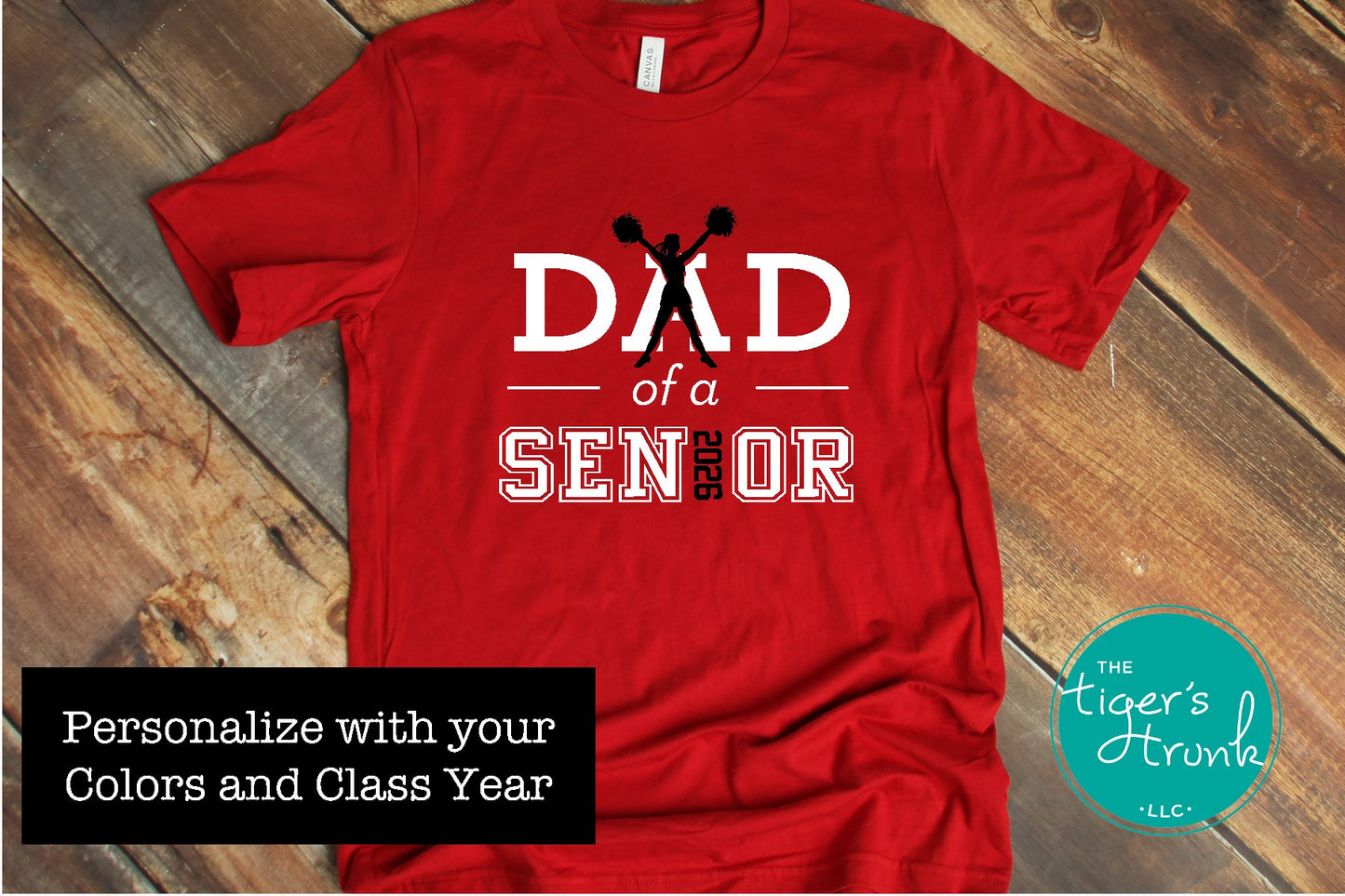 Red Cheer Dad of a Senior shirt shown in a flatlay with a rustic wood background.