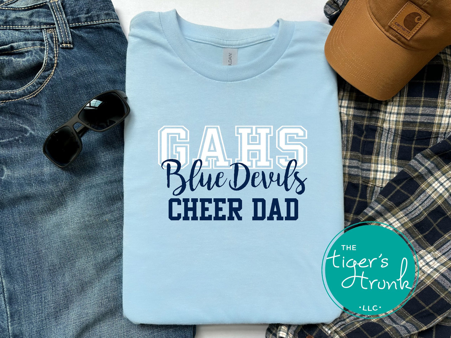 Light blue t-shirt with 'GAHS Blue Devils CHEER DAD' text, sunglasses, jeans, and a cap on a white background.
