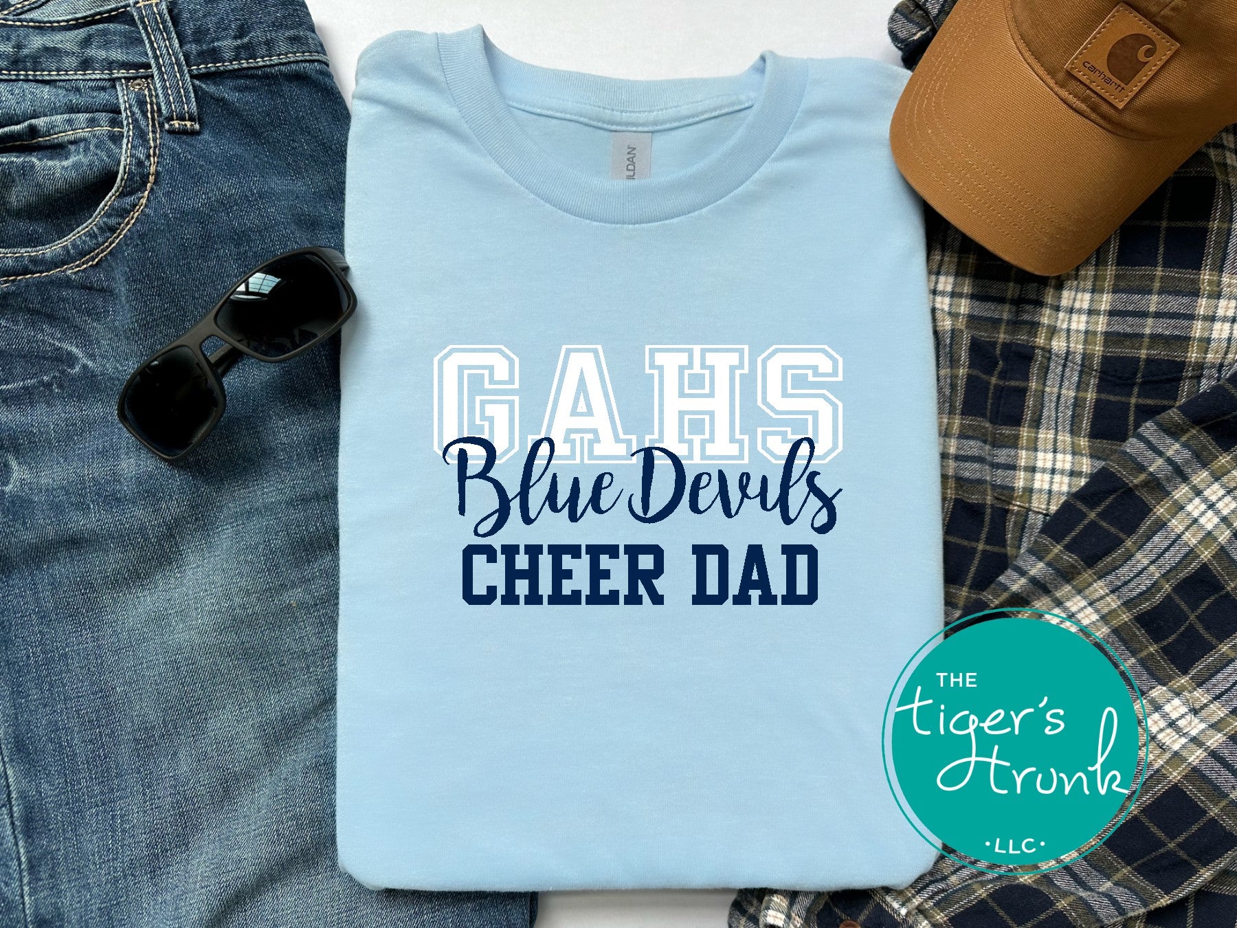 Light blue t-shirt with 'GAHS Blue Devils CHEER DAD' text, sunglasses, jeans, and a cap on a white background.