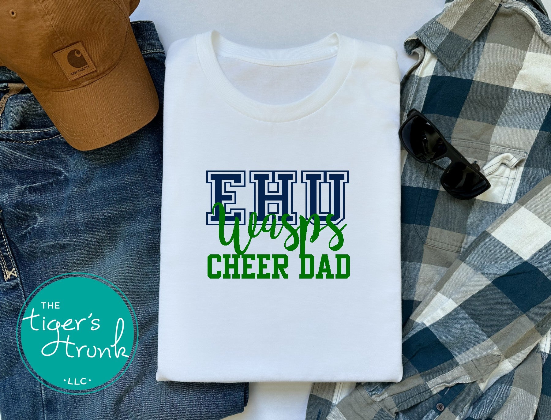White t-shirt with 'EHU Tigers CHEER DAD' text, surrounded by casual clothing and accessories.