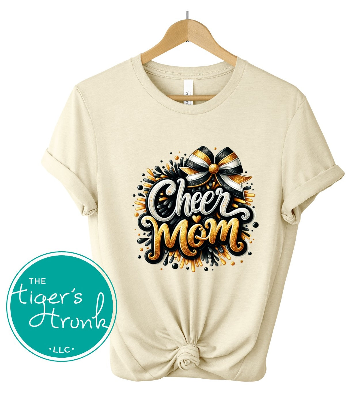 Natural t-shirt with 'Cheer Mom' design on a hanger, featuring The Tiger's Trunk logo.