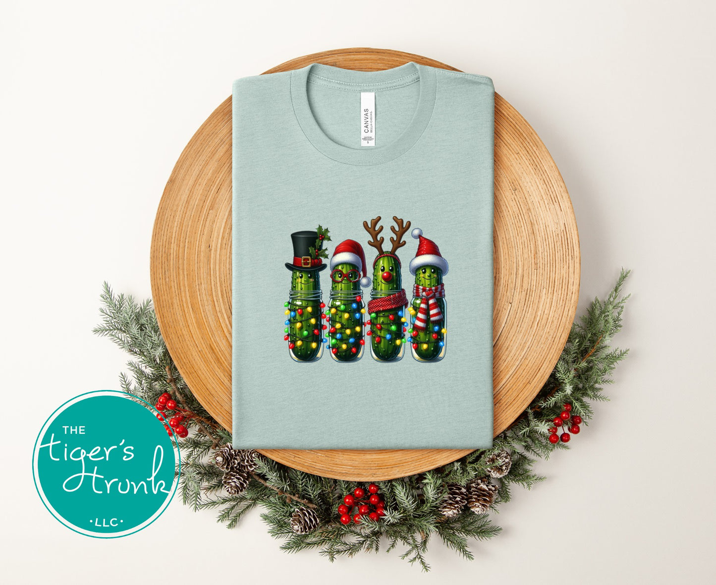 Light blue t-shirt with Christmas-themed design on a wooden stand with decorative elements.