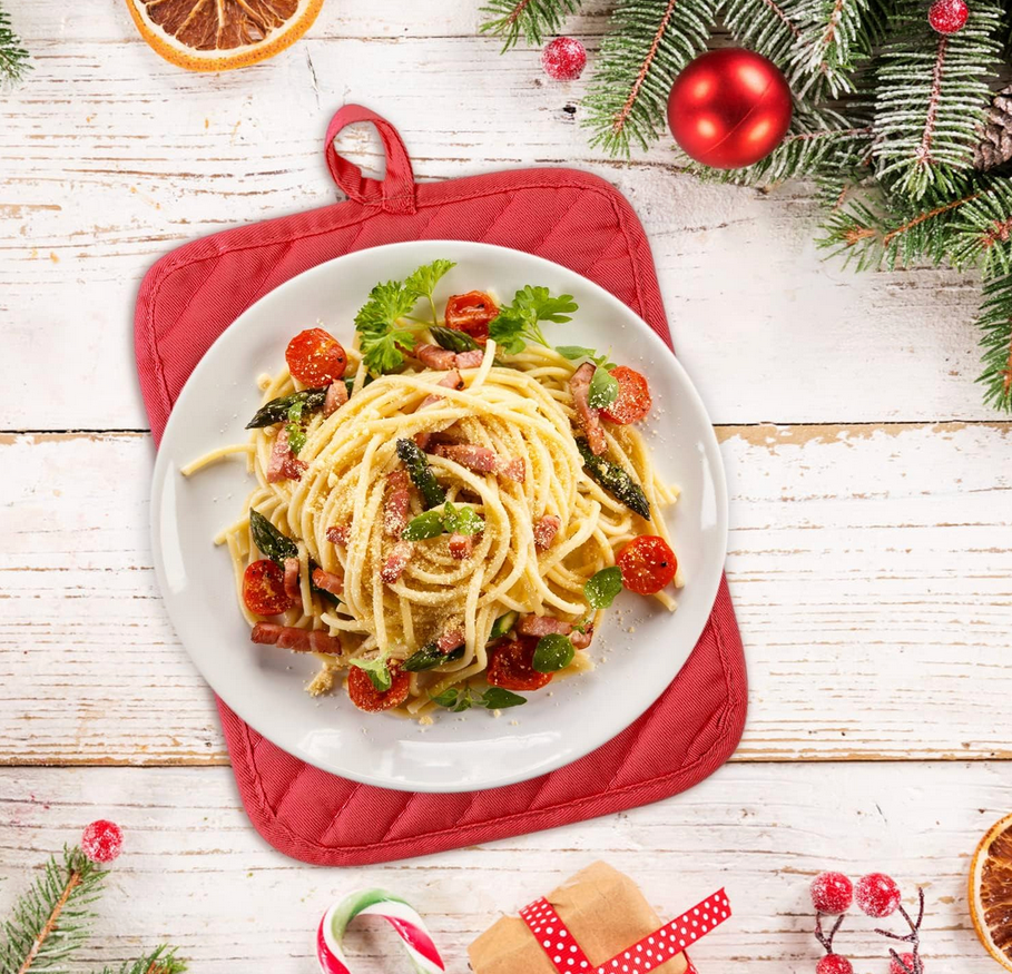 Plate of spaghetti with vegetables on a wooden table with Christmas decorations
