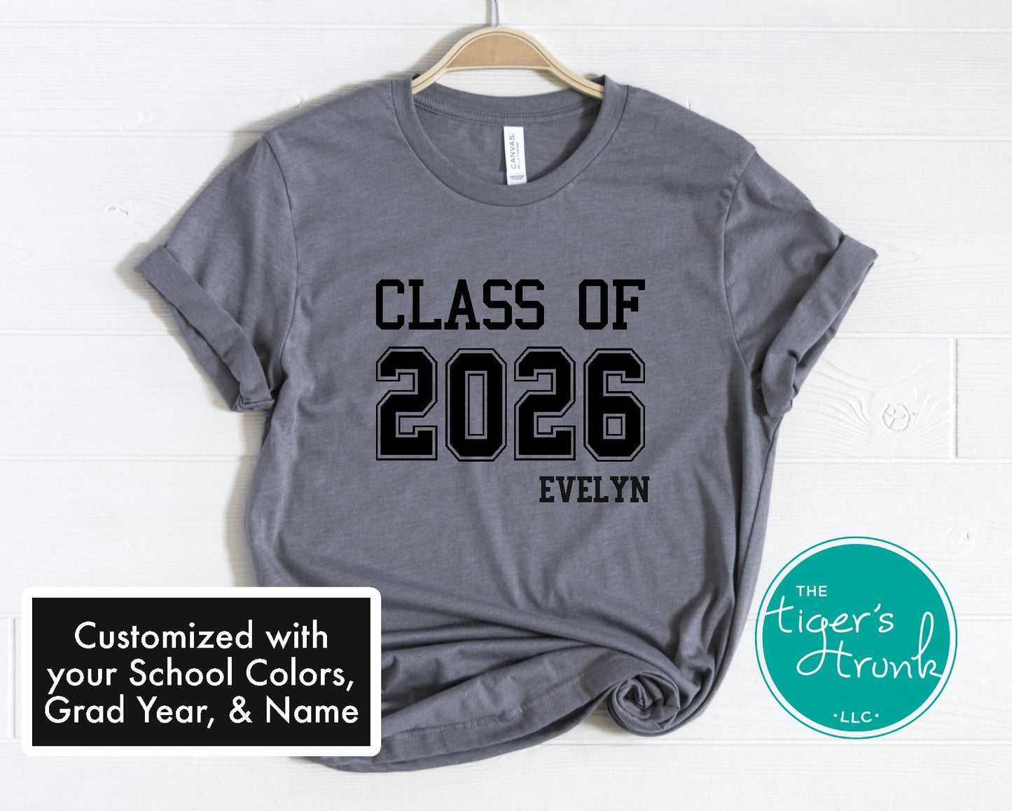 Gray t-shirt with 'Class of 2026 Evelyn' text on a hanger, branded with 'The Tiger's Trunk'.