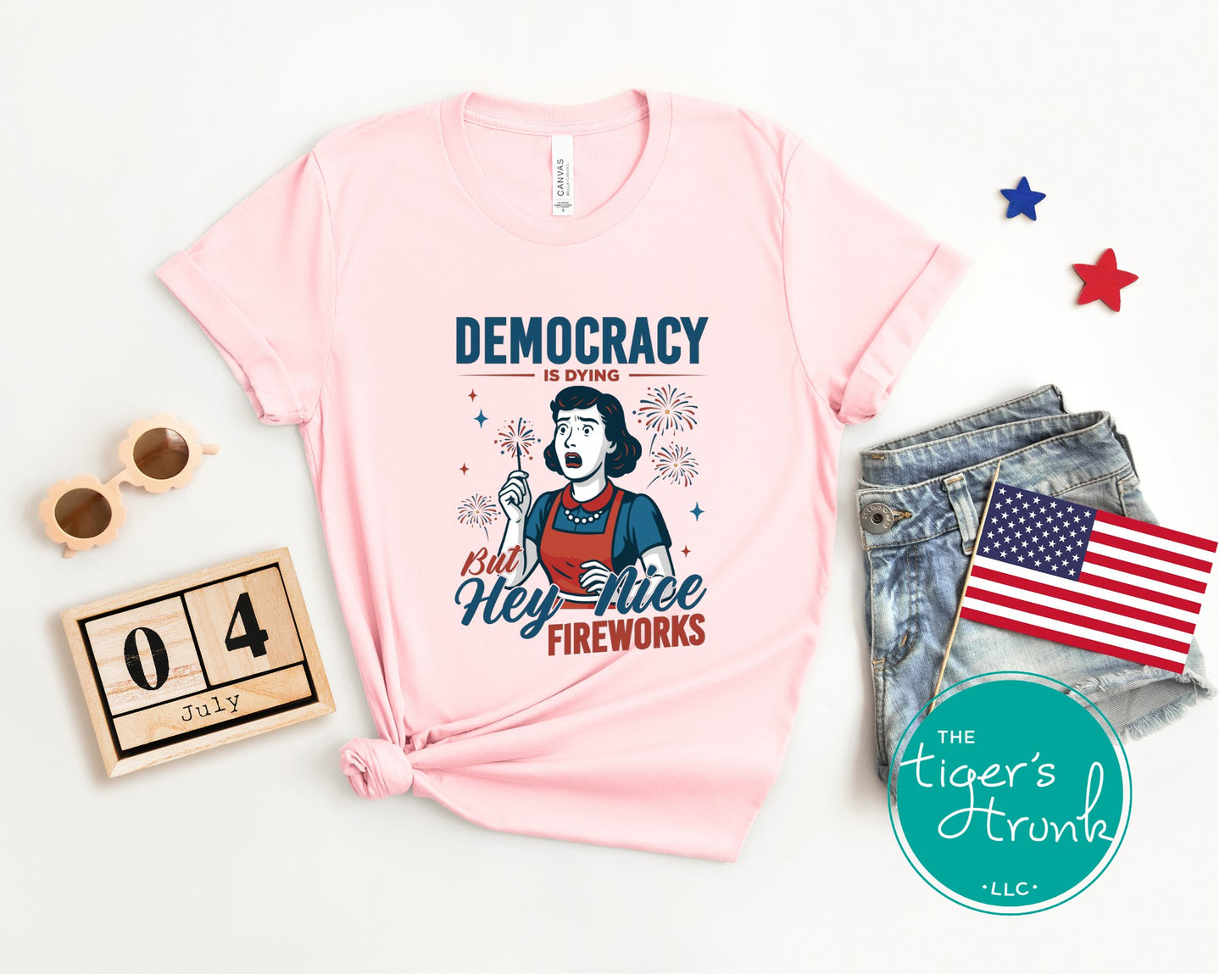 Funny political t-shirt that reads Democracy Is Dying But Hey, Nice Fireworks, worn for sarcastic July Fourth cookouts