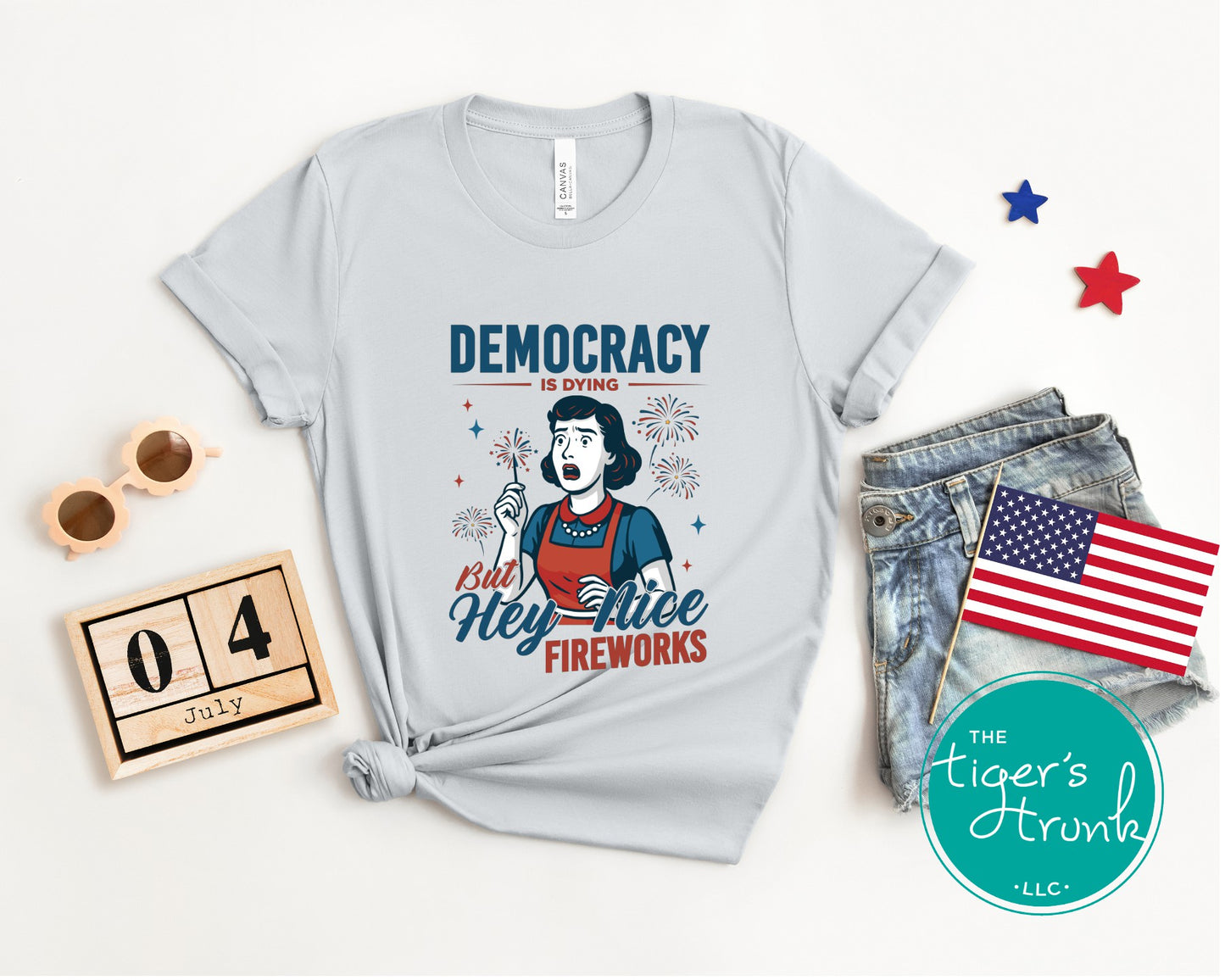 Funny political t-shirt that reads Democracy Is Dying But Hey, Nice Fireworks, worn for sarcastic July Fourth cookouts
