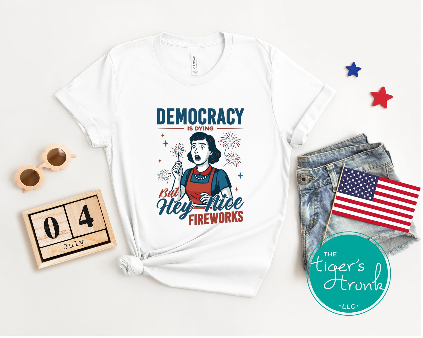 Funny political t-shirt that reads Democracy Is Dying But Hey, Nice Fireworks, worn for sarcastic July Fourth cookouts