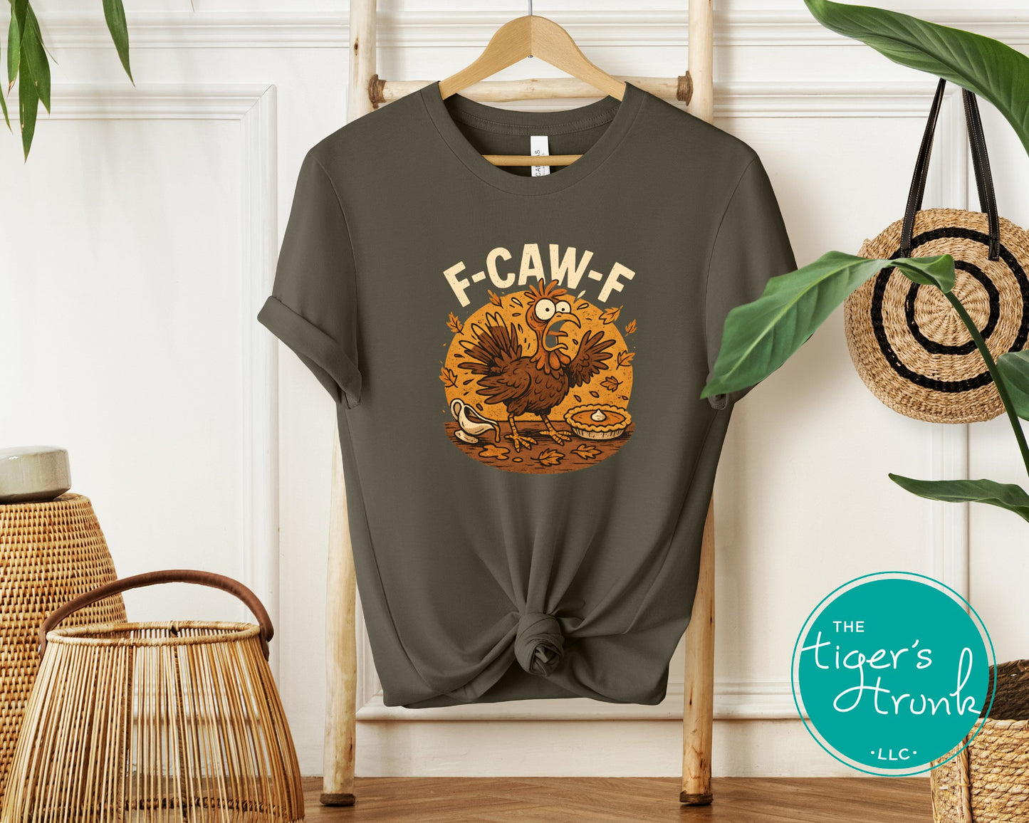 Gray t-shirt with a graphic design on a hanger against a white wall with decorative elements.