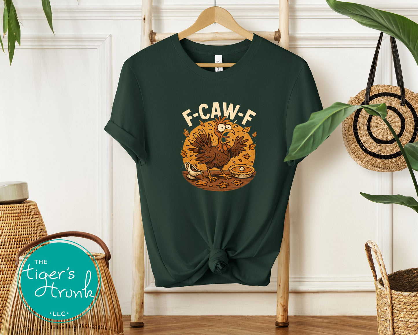 Green t-shirt with a graphic design on a hanger against a white wall.