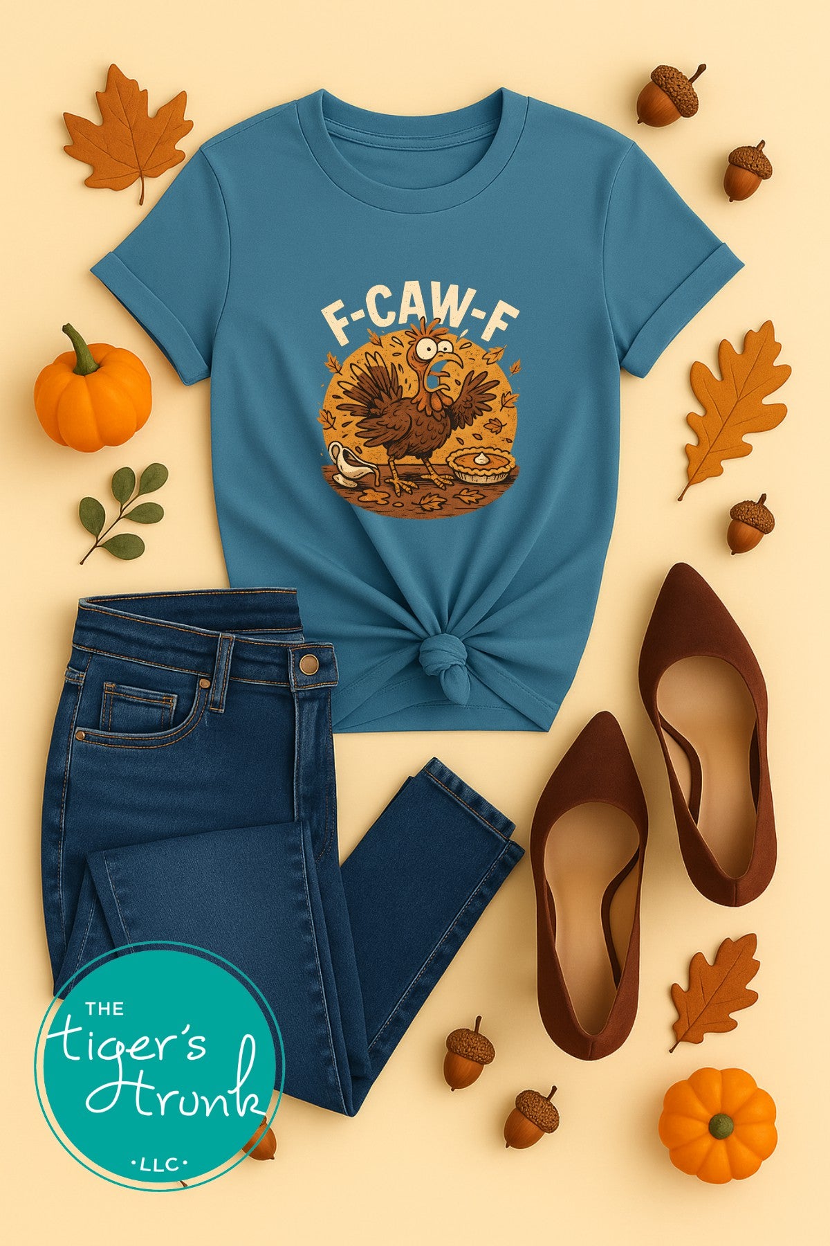 Blue t-shirt with a turkey graphic and text, paired with jeans and shoes on a beige background.
