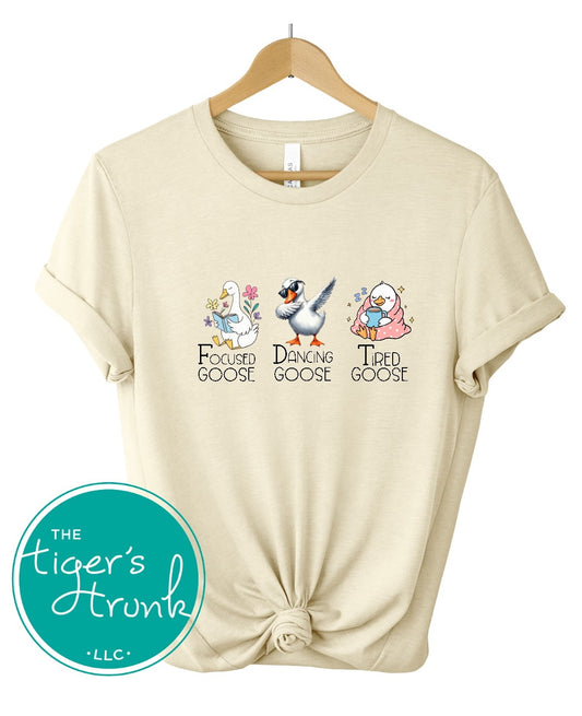 T-shirt featuring three geese labeled Focused Goose, Dancing Goose, and Tired Goose, discreet political humor design