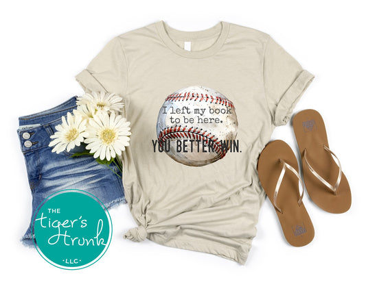 Beige t-shirt with baseball graphic and text, denim shorts, sandals, and flowers on a white background.