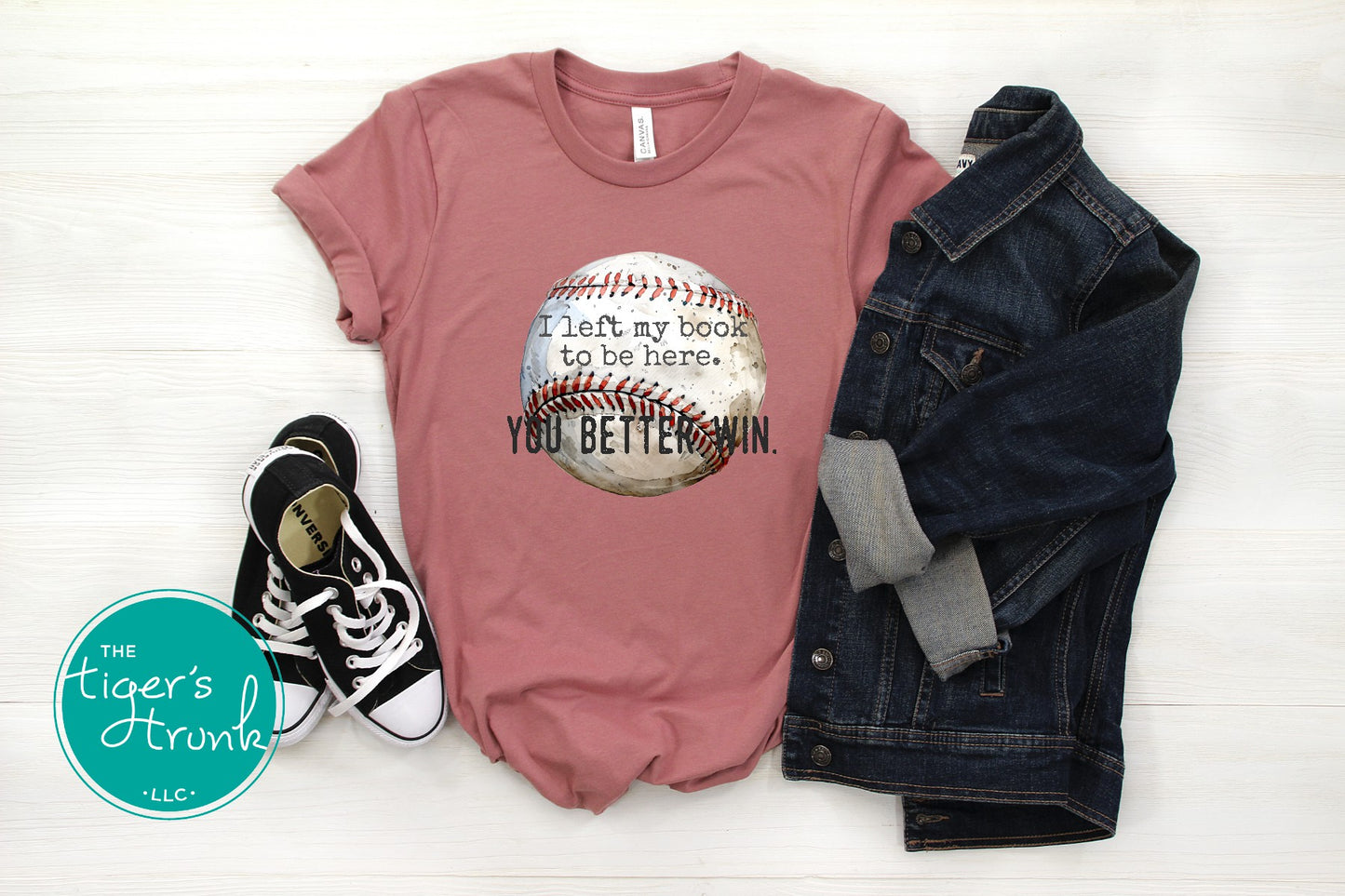 Pink t-shirt with baseball graphic and text, paired with denim jacket and sneakers on a white background.