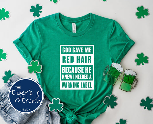 God Gave Me Red Hair Because He Knew I Needed a Warning Label shirt in kelly green with white block text styled for St Patricks Day with shamrock accents