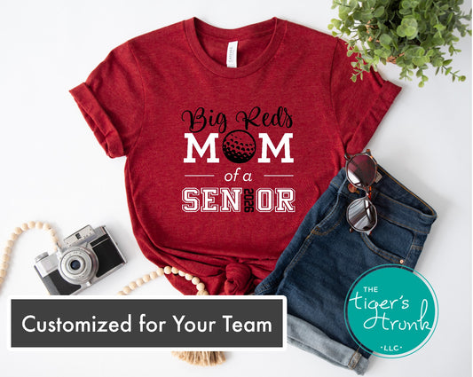 Red t-shirt with 'Big Red Mom of a Senior' text and a golf ball graphic, displayed with jeans and sunglasses on a white background.