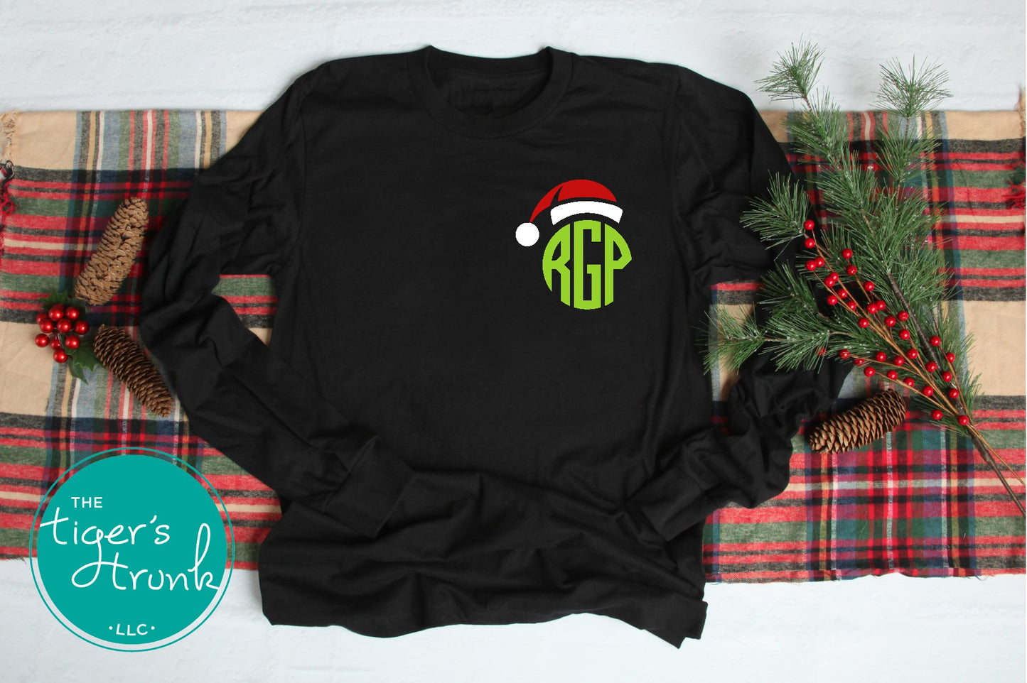 Black long-sleeve shirt with Christmas-themed design on a plaid fabric background