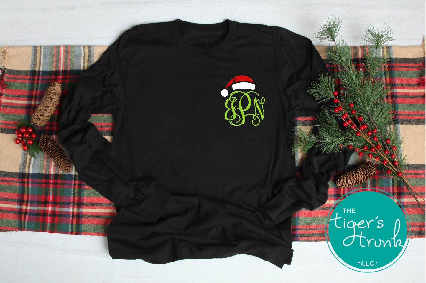 Black long-sleeve shirt with Christmas-themed design on a plaid fabric background