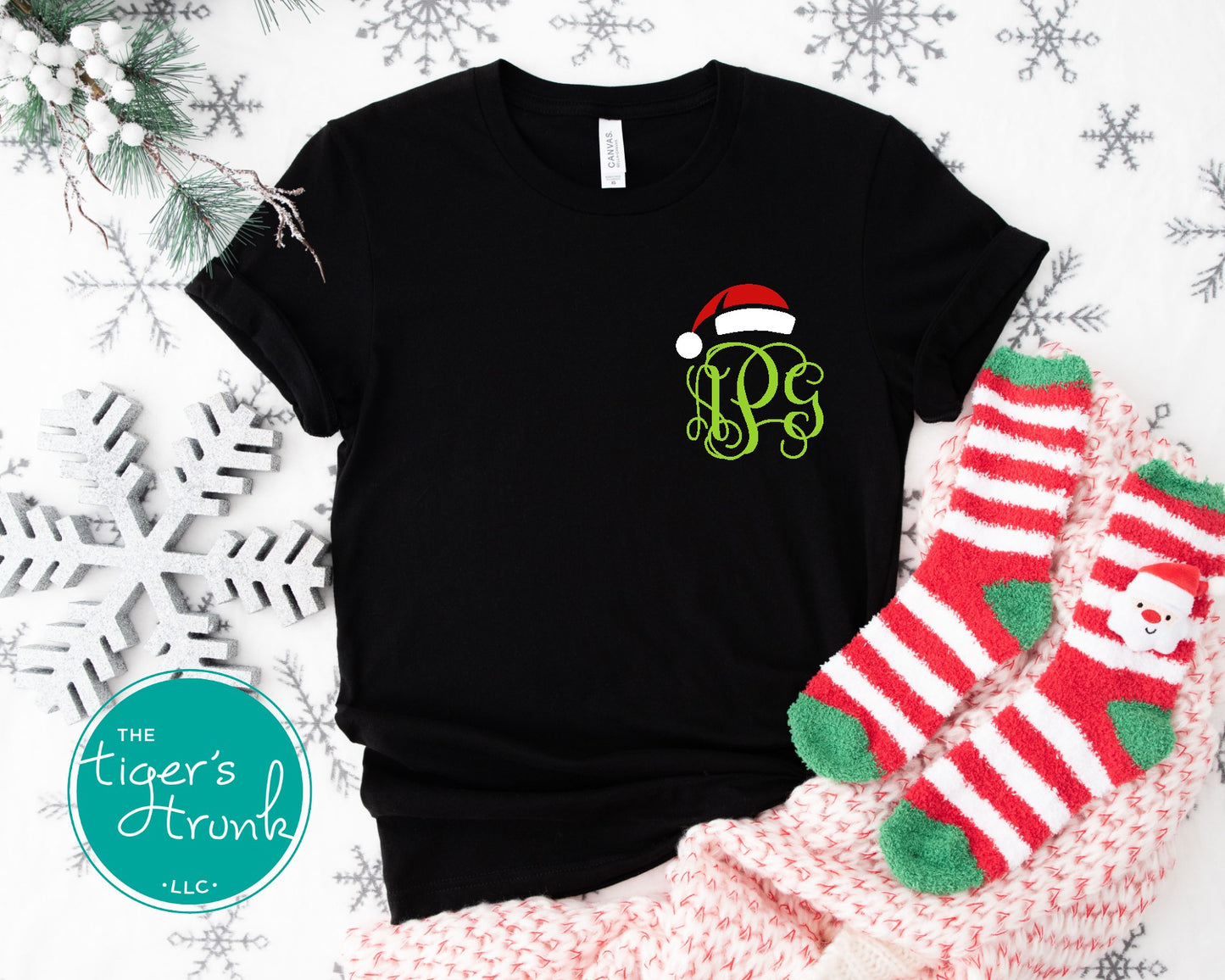 Black t-shirt with Christmas-themed design on a festive background with stockings and snowflakes.