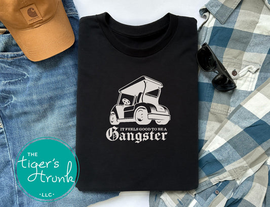 Black golf cart shirt with light tan graphic and the quote It Feels Good to Be a Gangster, funny golf tee, gift for golfer or dad