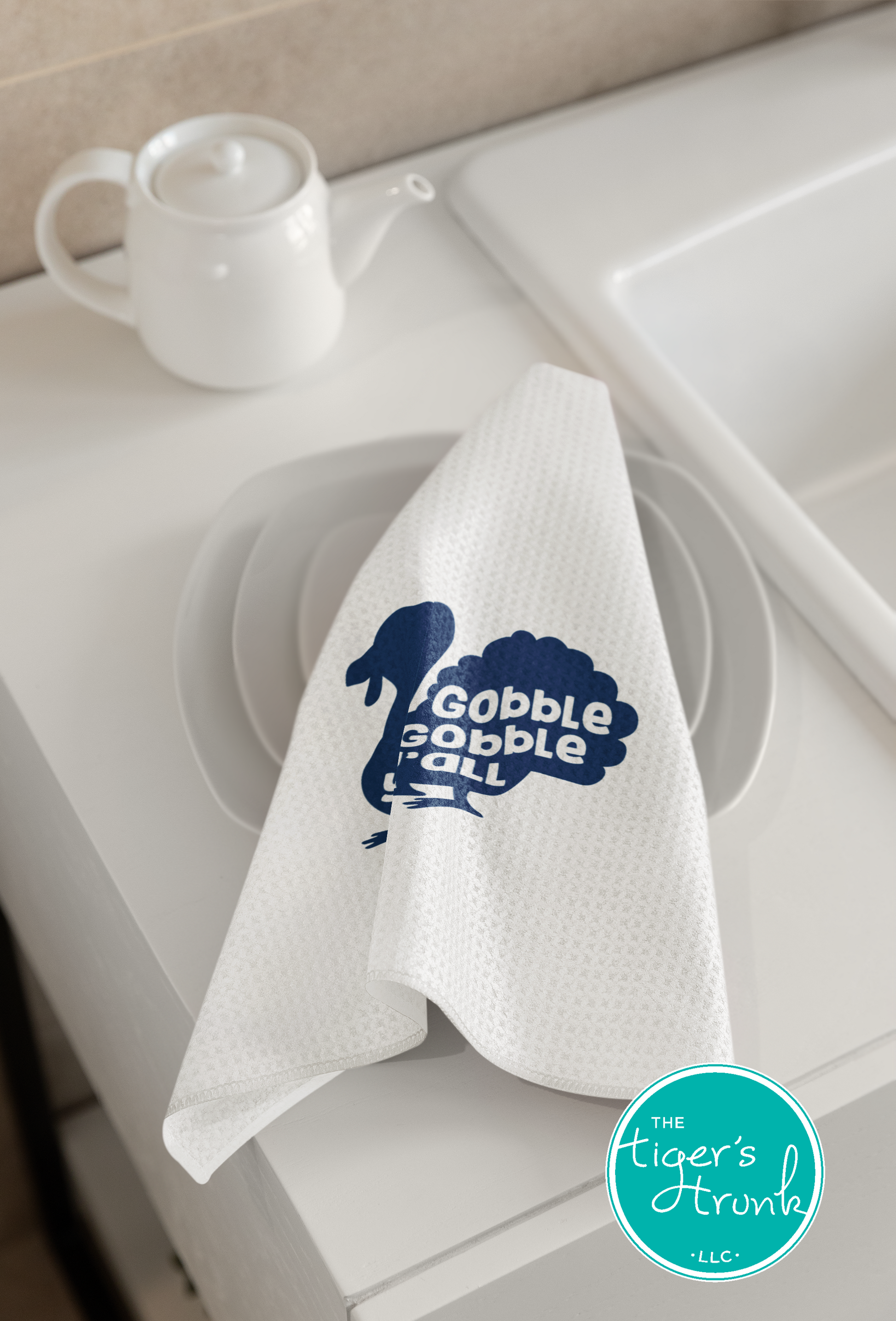 White towel with blue graphic and text on a kitchen sink