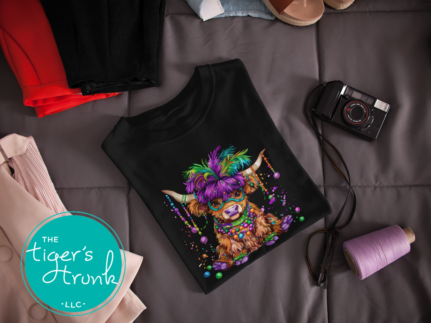 Mardi Gras t-shirt featuring a watercolor heifer adorned with colorful feathers and beads, perfect for festive celebrations.