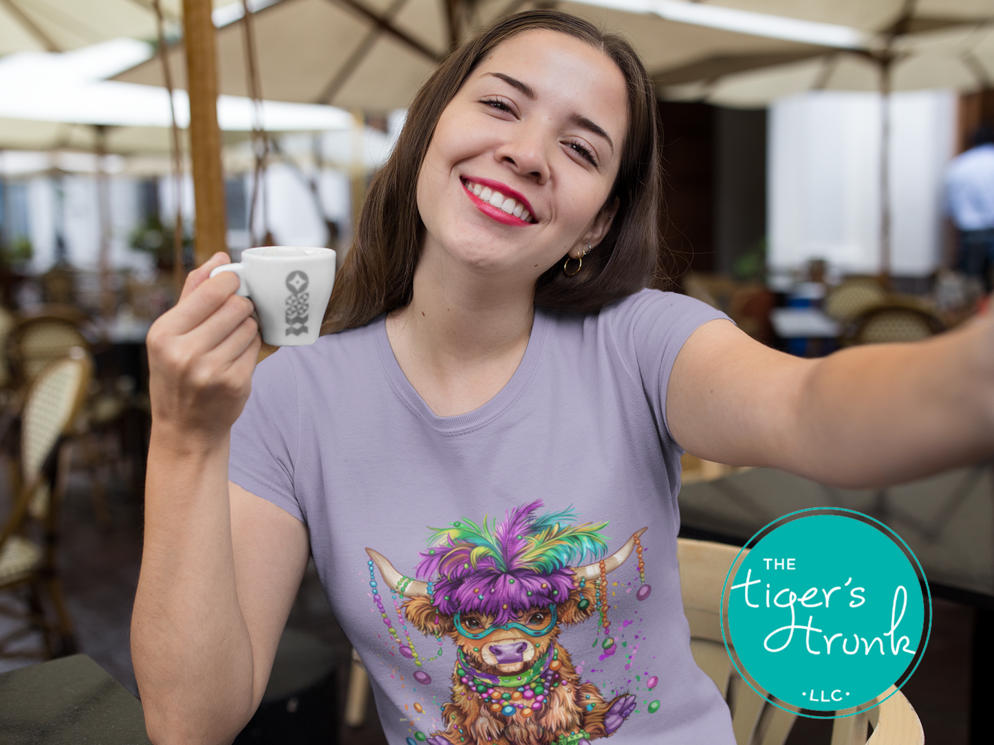 Mardi Gras t-shirt featuring a watercolor heifer adorned with colorful feathers and beads, perfect for festive celebrations.