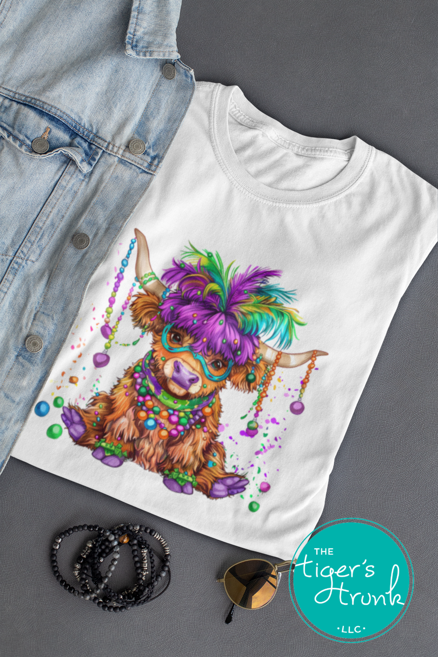 Mardi Gras t-shirt featuring a watercolor heifer adorned with colorful feathers and beads, perfect for festive celebrations.