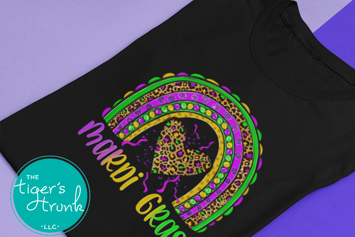 Mardi Gras t-shirt featuring the word "Mardi Gras" with a rainbow design in purple, green, and gold.