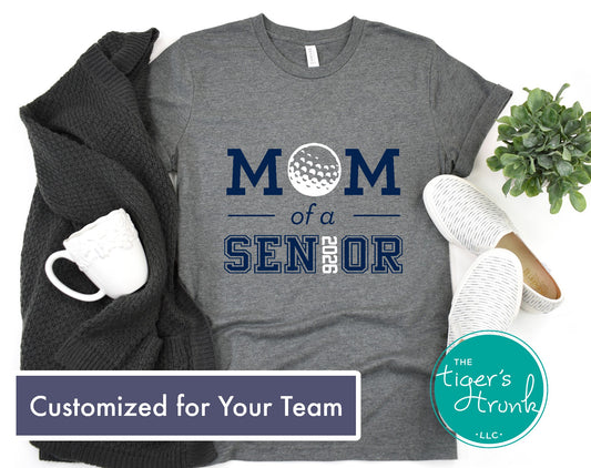 Gray t-shirt with 'Mom of a Senior' text, mug, plant, and sweater on a white background