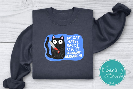 Dark gray sweatshirt with a graphic of a cat and text on a light wooden surface, featuring the brand 'The Tiger's Trunk'.