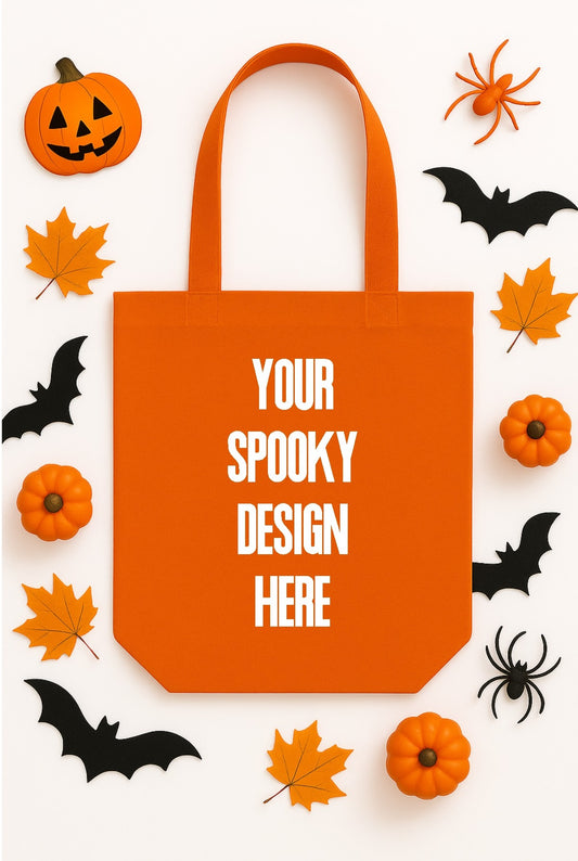 Orange tote bag with 'Your Spooky Design Here' text, surrounded by Halloween decorations on a white background.