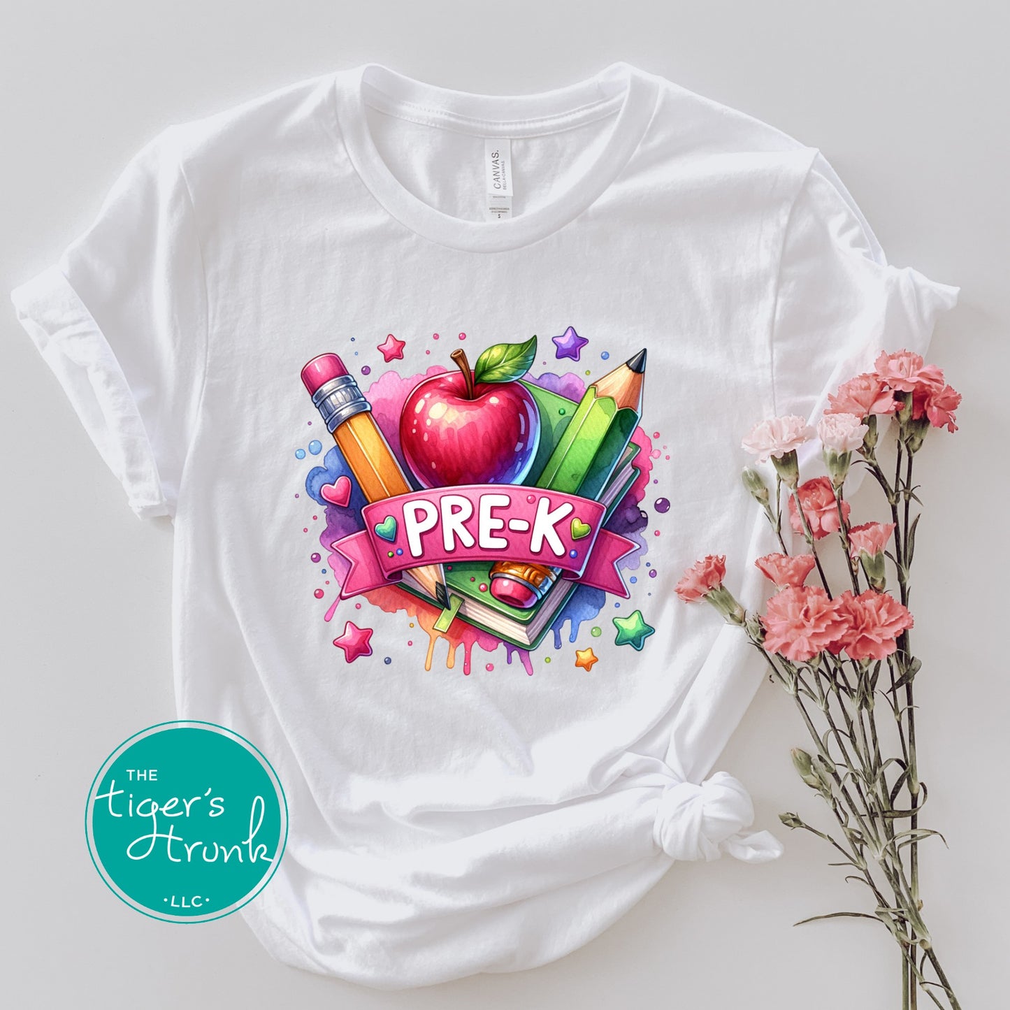 White t-shirt with colorful 'PRE-K' design featuring an apple, pencils, and books on a light gray background.