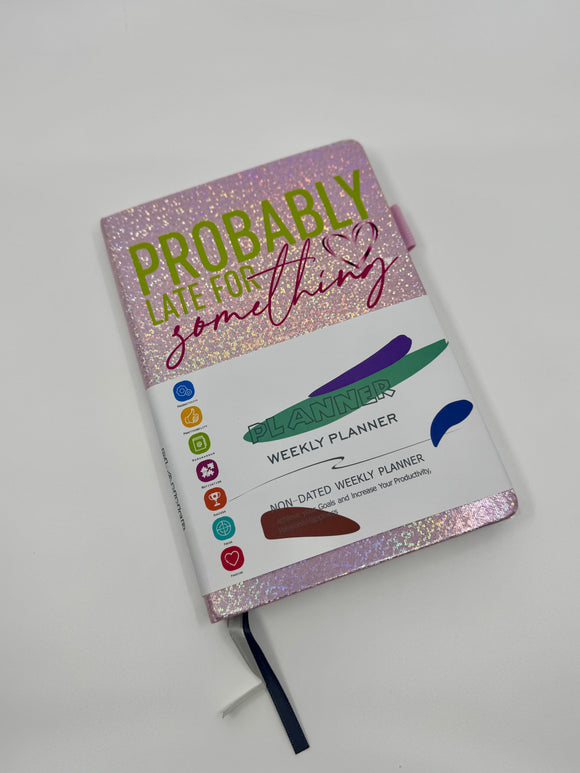 A pink sparkly hardback weekly planner with the phrase 