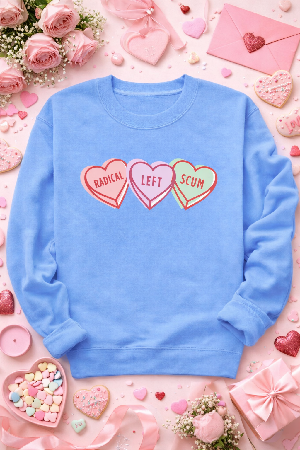 Blue sweatshirt with heart-shaped text surrounded by decorative items on a pink background