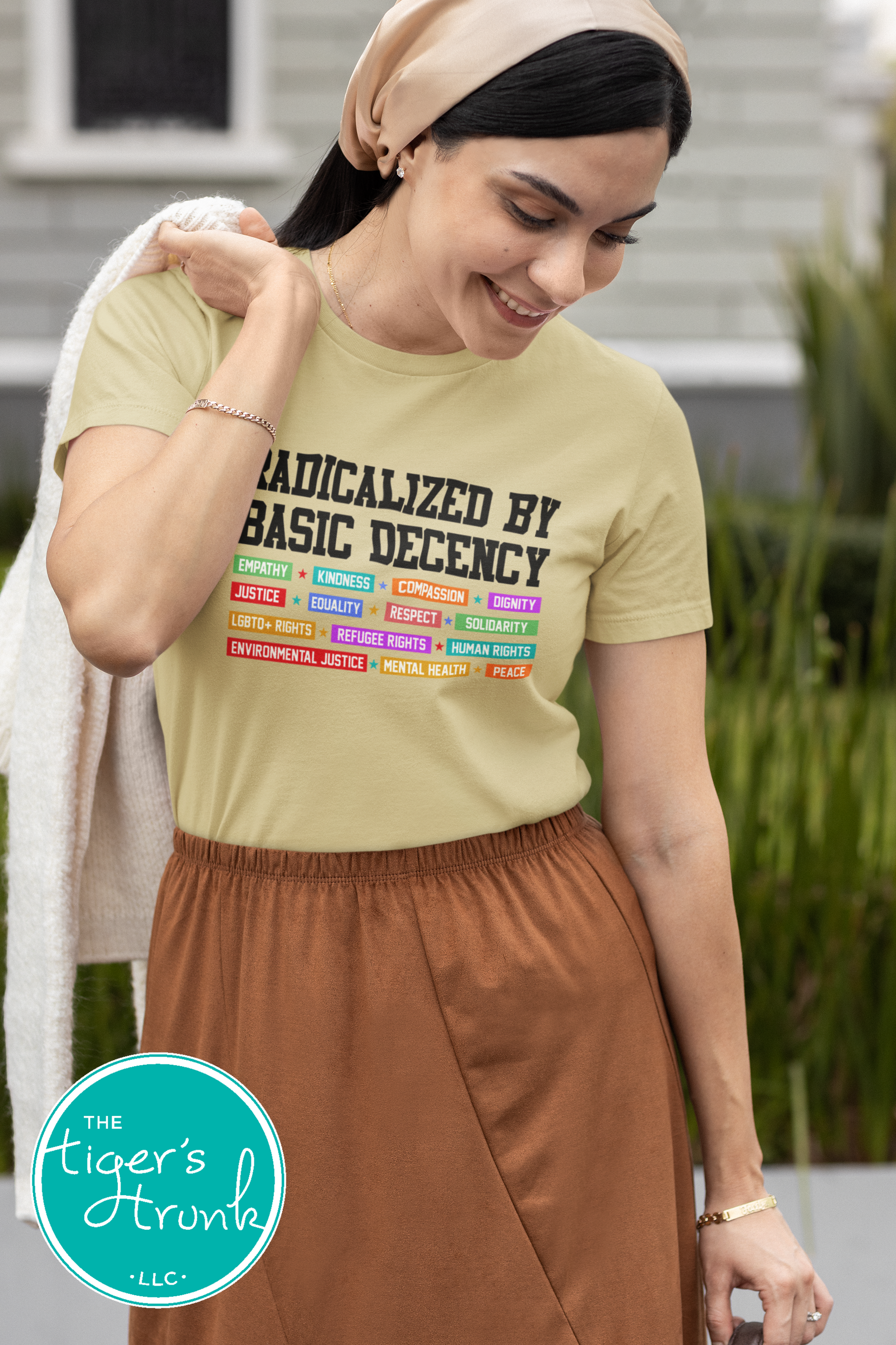 Woman wearing a t-shirt with text and colorful graphics, standing outdoors.