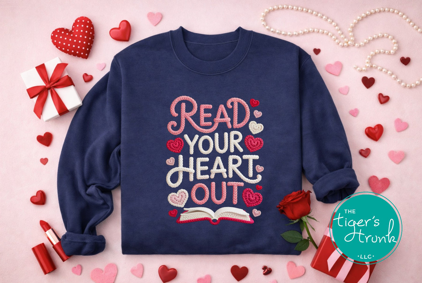 Navy blue sweatshirt with 'Read Your Heart Out' text on a pink background with hearts and decorative items.