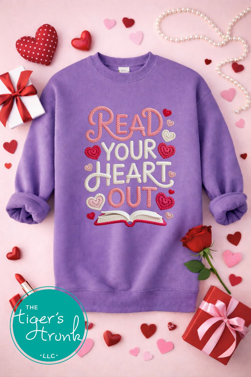 Purple sweatshirt with 'Read Your Heart Out' text on a pink background with hearts and roses, featuring The Tiger's Trunk logo.
